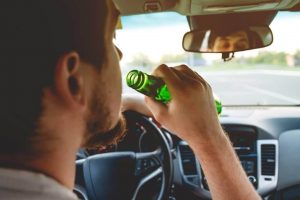man driving with beer