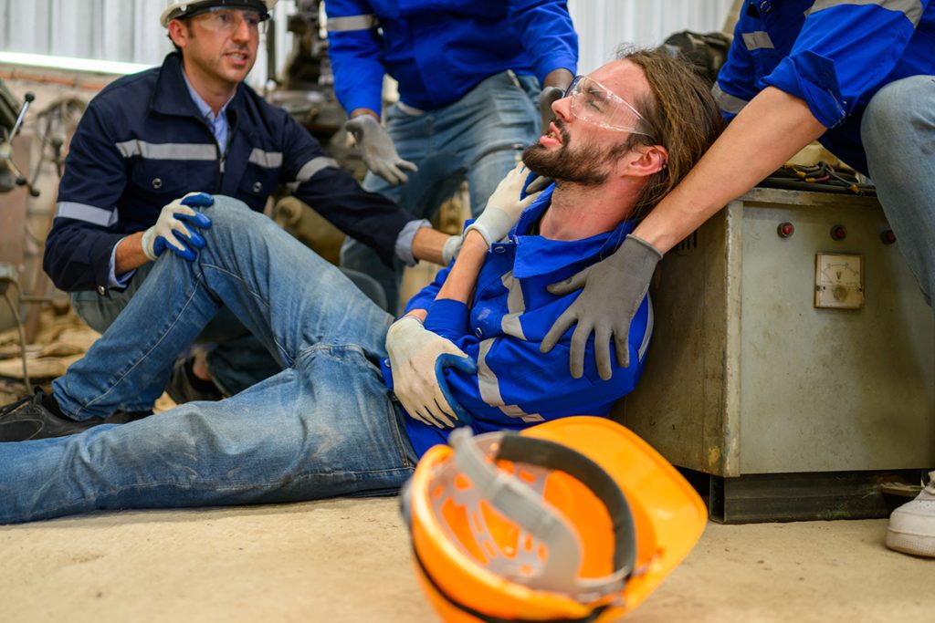 An injured worker surrounded by other workers